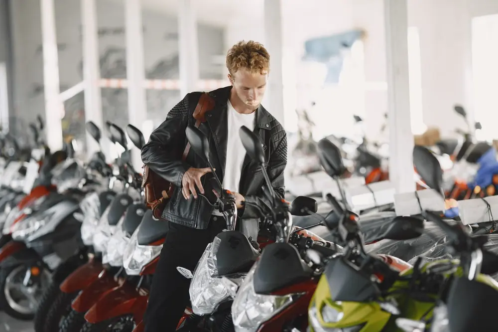Cliente revisando motocicletas en el catálogo de una agencia