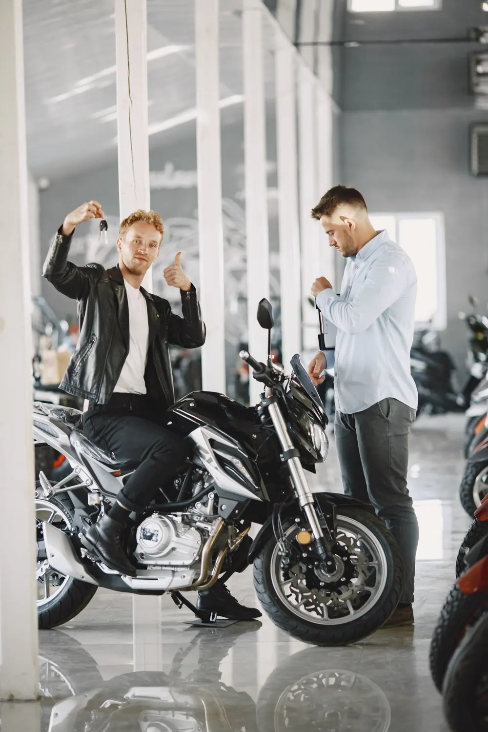Cliente recibiendo las llaves de su motocicleta nueva en una agencia