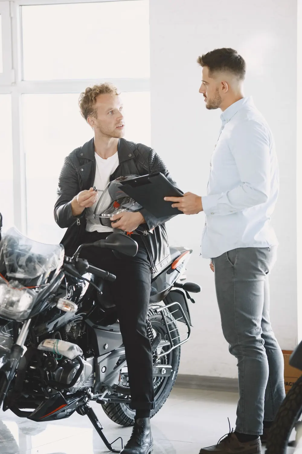 Asesor y cliente conversando sobre una motocicleta en una agencia